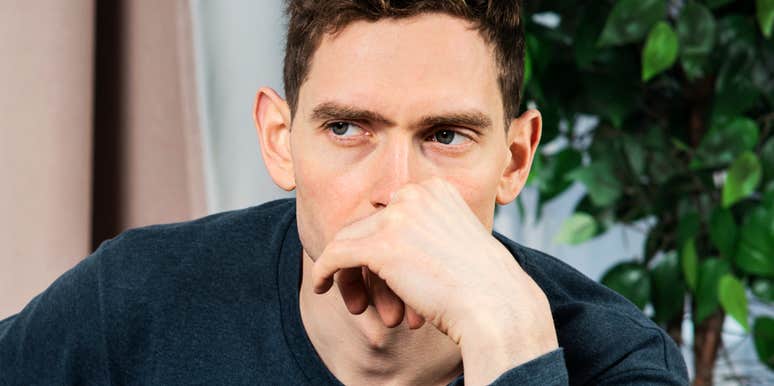 Man's fist pressed near his mouth and guarded gaze reflect the tension anxiety can leave unspoken.
