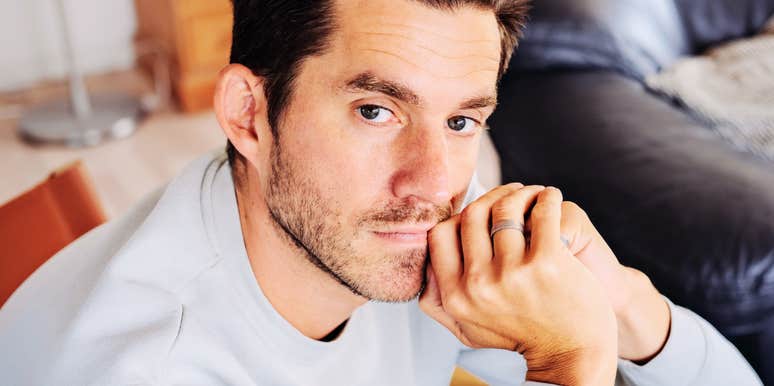 Man with wedding ring looking pensive, reflecting quiet guilt over betraying a partner