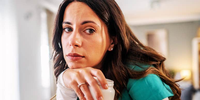 Woman rests her chin on her hand, a pensive look that mirrors the worry of sensing distance in a relationship.