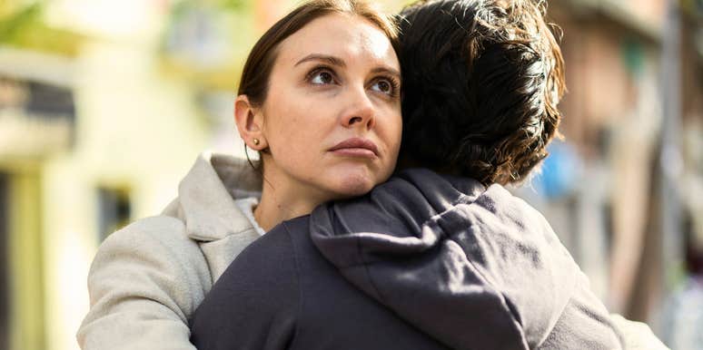 Woman who looks like she doesn't love a man hugs him and seems annoyed