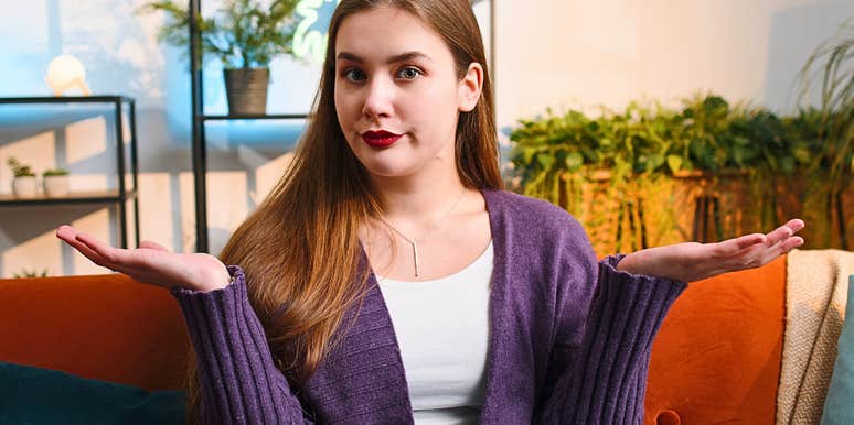 Woman roommate who is annoying shrugs on a couch 