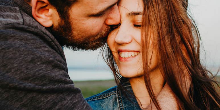 Eyes closed, she smiles into his kiss, the kind of unguarded tenderness that speaks for itself.