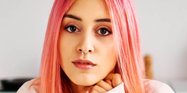 Woman with intense, fixed gaze resting chin on hands, hinting at consuming thoughts of someone