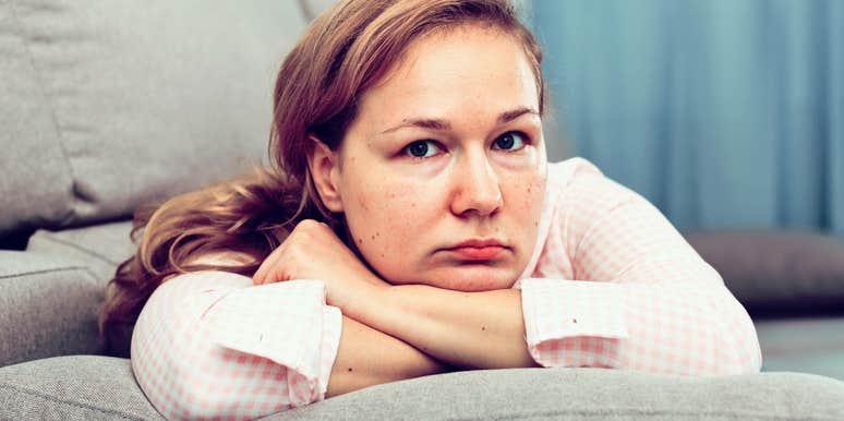 Woman who looks stressed and lacking affection looks sad on a couch