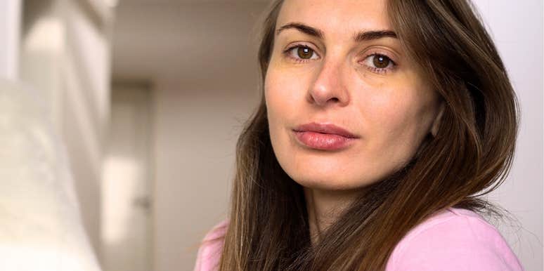 woman who looks a little lonely smiles sadly 