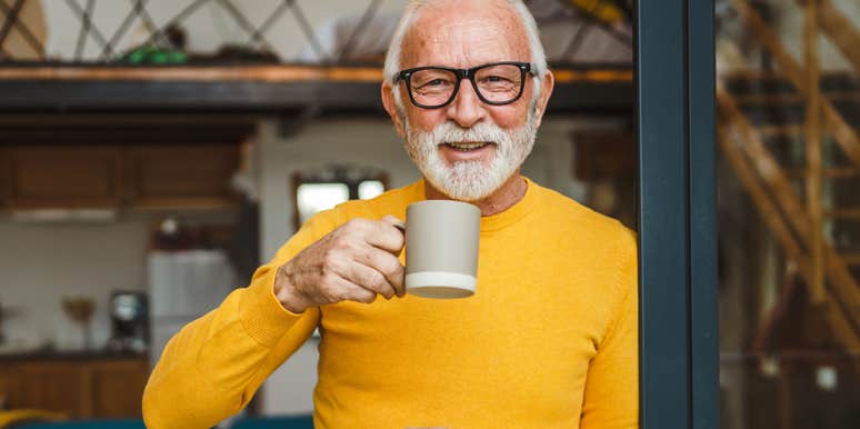 older man who is naturally good at lots of things smiles and sips coffee