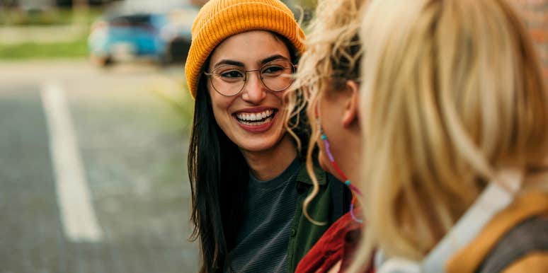 smiling woman talking to acquaintances to prevent a lull