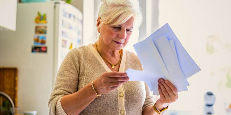 boomer woman opening her mail at home