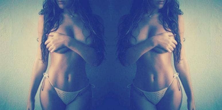 woman holding breast in bikini bottoms woman holding breast in bikini bottoms