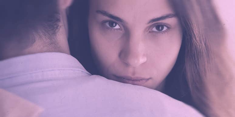 4 Little Things Women Do That Men Count As Cheating couple hugging, woman looking at the camera