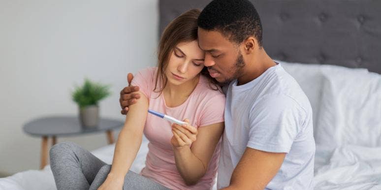 unhappy couple looking at pregnancy test