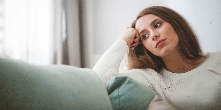 5 Undeniable Signs You're A Rebound Girl woman thinking of something sitting on couch