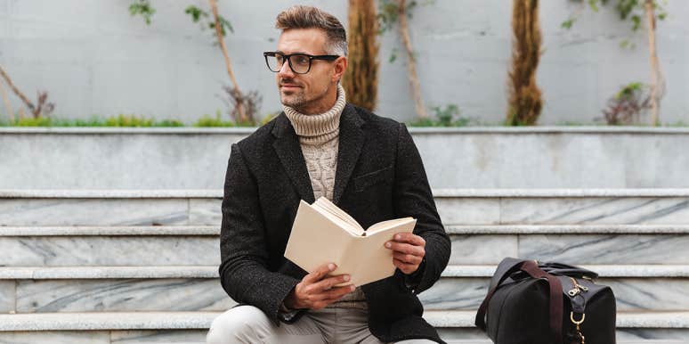 smart man reading book on bench
