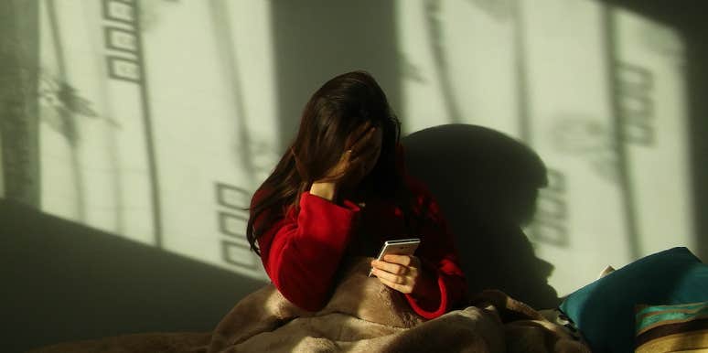 sad girl sitting with her phone