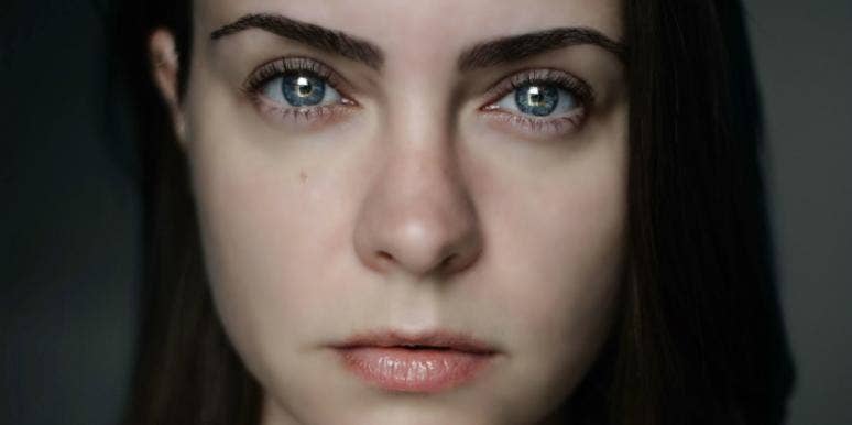 The Disturbing Way Negative Emotions Impact Your Physical Health woman with dark hair staring directly at camera