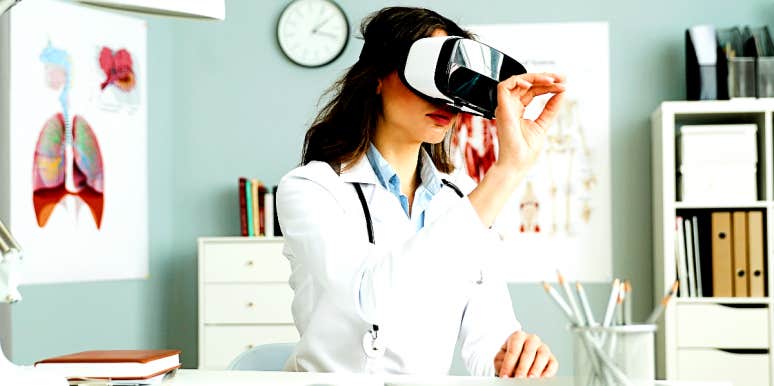 Physician sitting at her desk wearing VR mask to diagnose patient