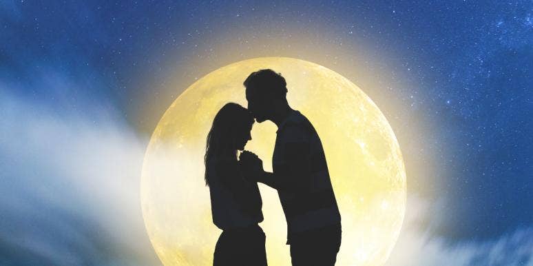 Couple silhouetted against moon