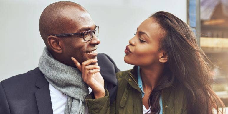 14 Easy Ways To Deepen Emotional Intimacy With Your Partner Woman holds a mans chin in her hands as she makes a kissing face
