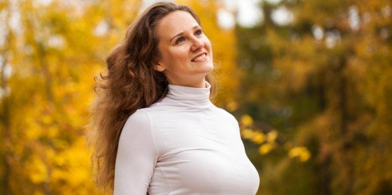 It’s Okay To Feel That You’re Behind In Life Compared To Everyone Else woman smiling in foliage