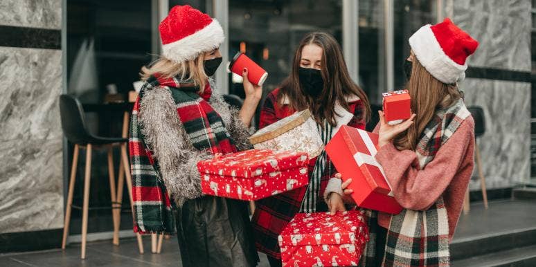 3 girls in Christmas attire exchange gifts