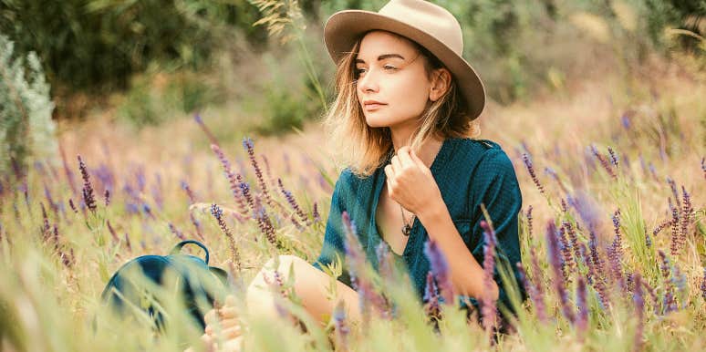 woman in hat sits calmly in lavender field 