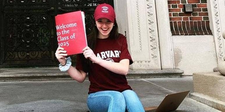 Abigail Mack wearing some Harvard merch and posing with an acceptance folder from the university.