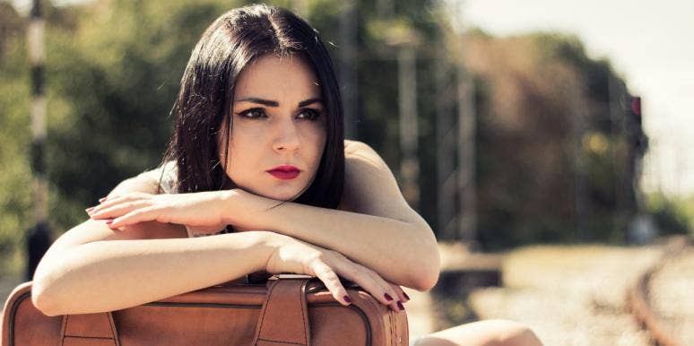 abusive relationships and grief sad woman with arms on top of luggage