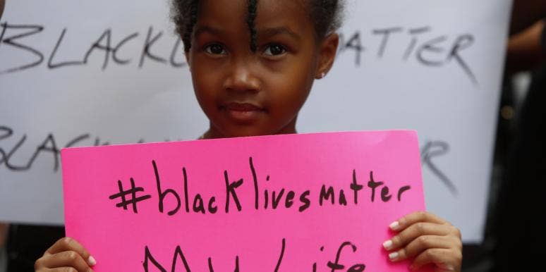 Black child holding a Black Lives Matter sign