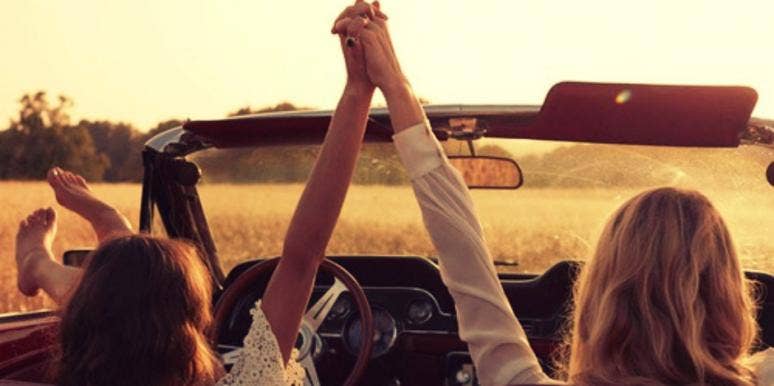 two women holding hands on road trip two women holding hands on road trip