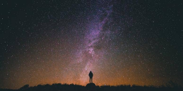 Man standing in front of starry backdrop Man standing in front of starry backdrop