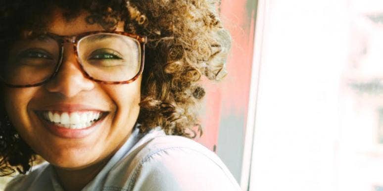woman with glasses and curly hair smiling