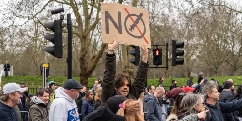 Breitbart Claims 'Organized Left' Don't Want Conservatives To Get Vaccinated So They Die anti vax man holding sign