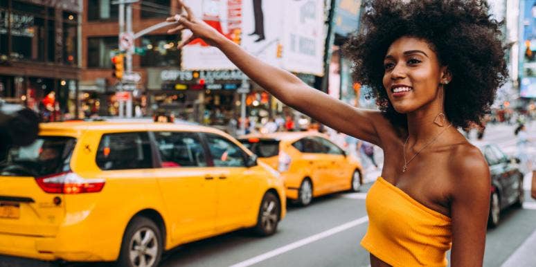 woman in yellow hailing a taxi cab