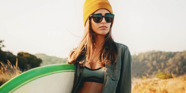 Behaviors that can become compulsions blonde woman in beanie carrying a surfboard
