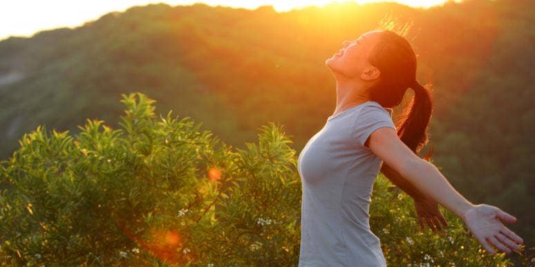 7 Reasons Being Single Makes You Healthier, Says Study woman holding out arms in sunshine