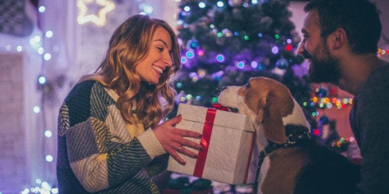 Best Beauty Products To Give As Stocking Stuffers (2020) husband and dog giving wife christmas gift
