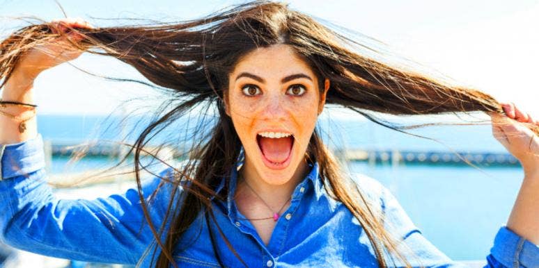 woman holding her hair with tongue out looking happy