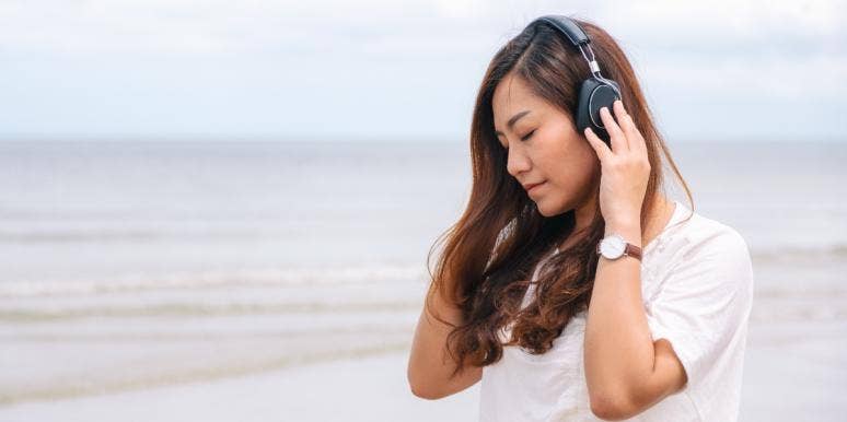 woman listening to headphones on beach