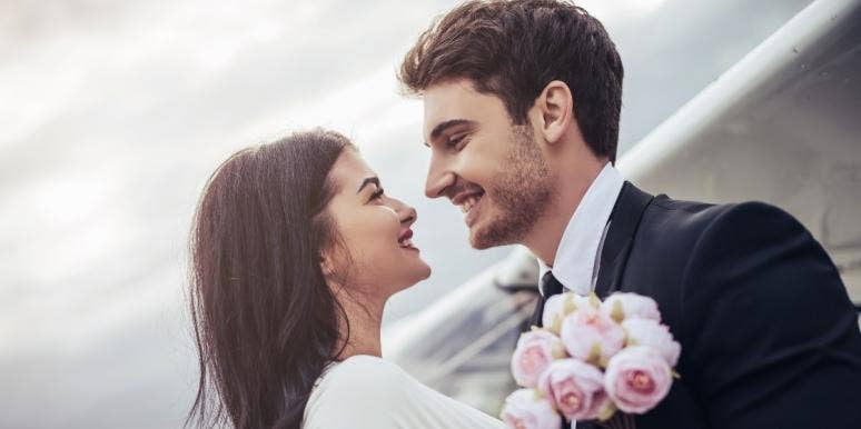 Best Wedding Songs: Songs About Marriage & Getting Married couple smiling at each other on their wedding day