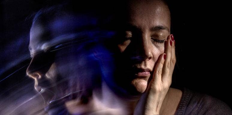 12 Big Signs You (Or Someone You Love) Has Bipolar Disorder woman holding cheek in shadow