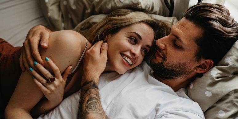 What Your Birth Order Says About Your Love Life couple smiling hugging in bed