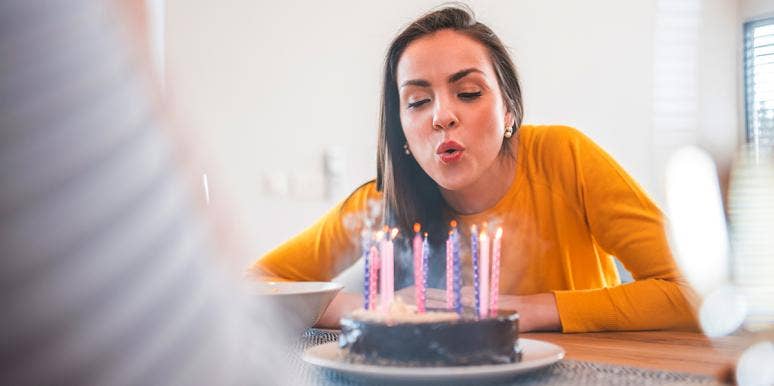 woman blowing out birthday candles