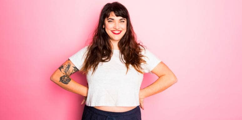 Born During Mercury Retrograde? Here’s What It Means smiling woman in white shirt with pink background