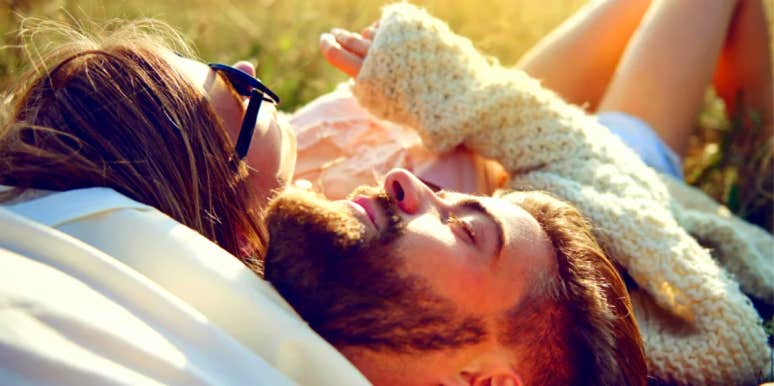 Is Your Boyfriend Being Distant? How To Fix It And When To Give Up couple laying in the grass together while boyfriend is being distant