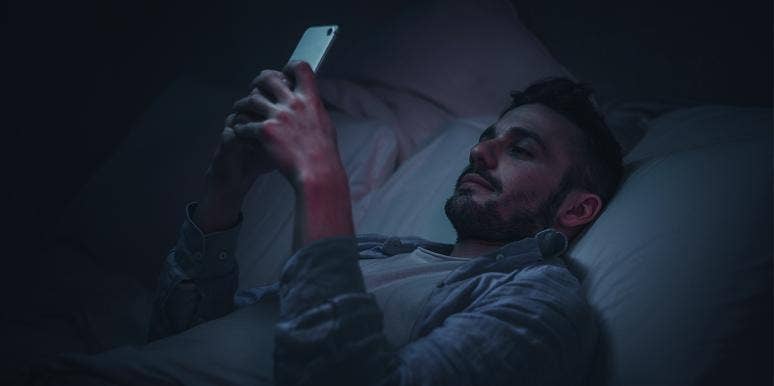 What To Do When Your Boyfriend Looks At Porn man laying in bed at night looking at phone