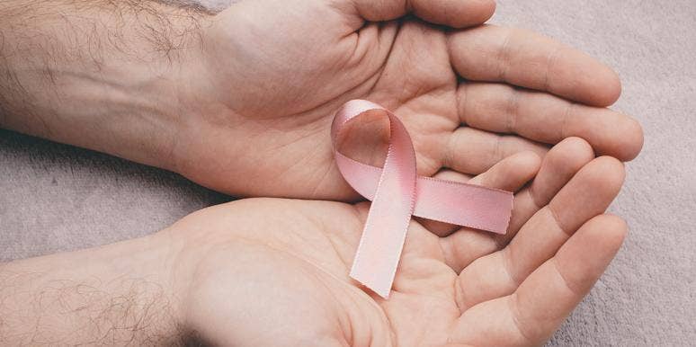 woman holding breast cancer pin