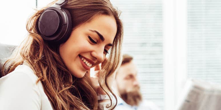 Woman listening to brown noise through headphones & smiling