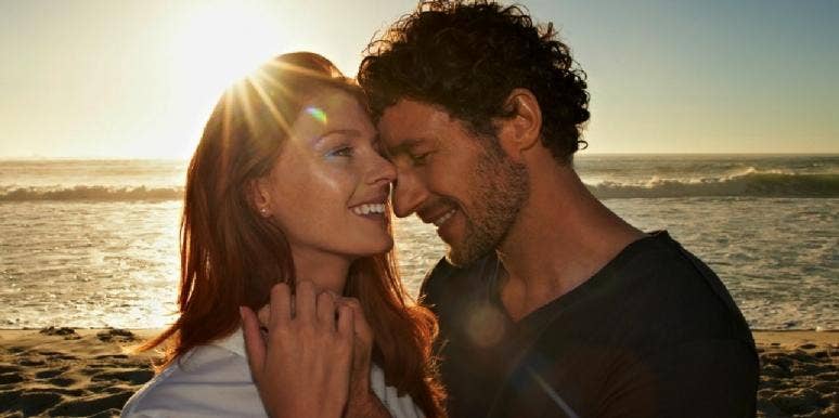 man and woman smiling on the beach