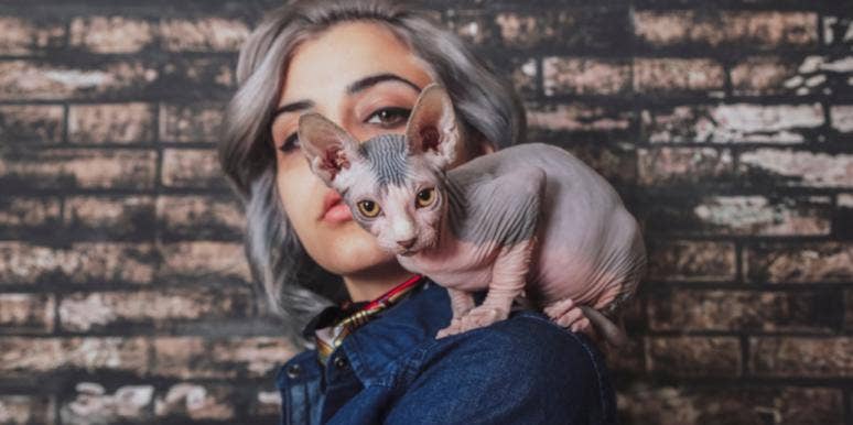 woman with hairless cat on shoulder