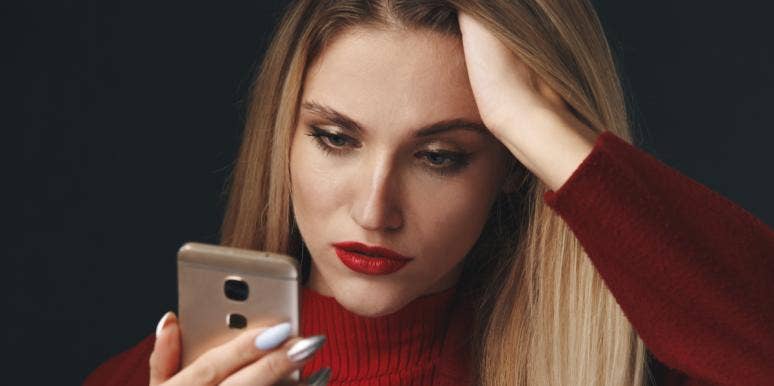 6 Ways To Avoid Being Catfished (And How To Catch One Red-Handed) woman looking at her phone